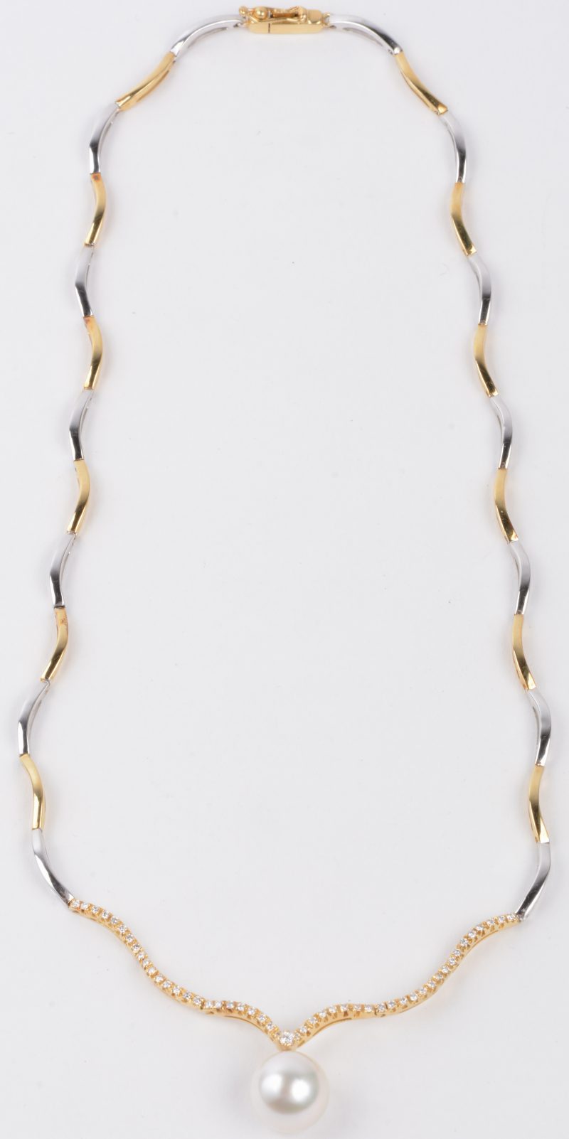 Een 18 karaats wit en geel gouden halssnoer bezet met briljanten met een gezamenlijk gewicht van ± 0,40 ct. en een South-Sea parel van 11,60 mm.
