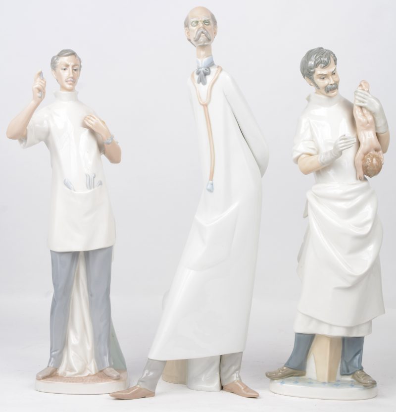 Drie beeldjes van porselein met voorstelling van figuren uit de medische wereld. Klein manco aan de hand van de tandarts. Onderaan gemerkt.