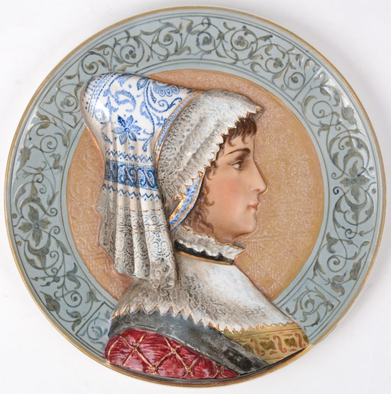 Een sierschoteltje van Weens porselein, met voorstelling van een vrouw in traditionele klederdracht. Achteraan gemerkt.