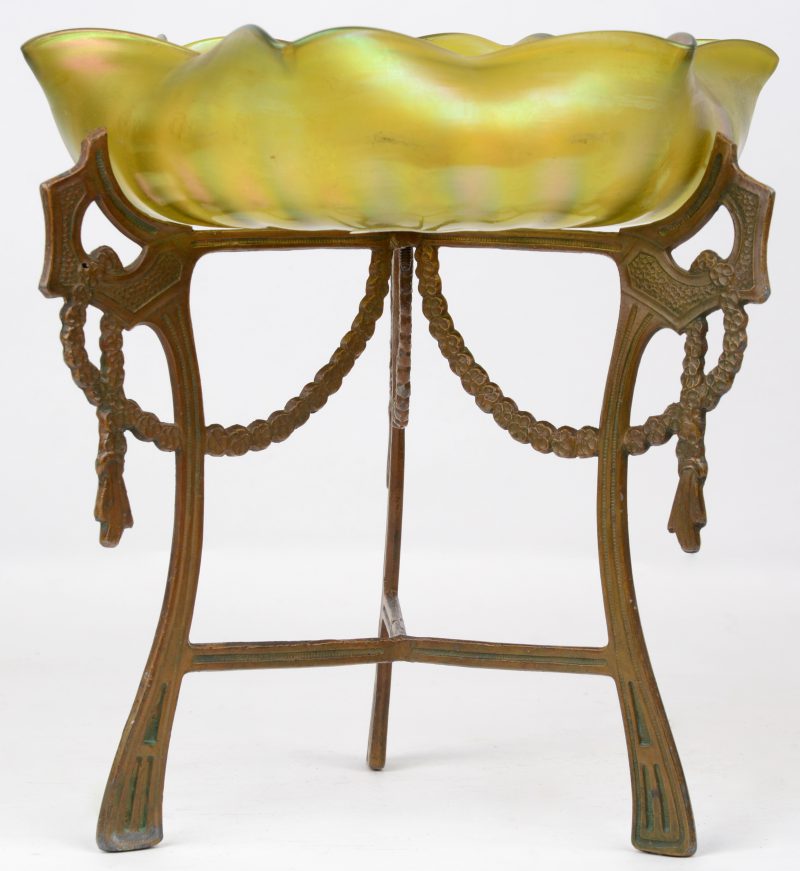 Een schotel van iriserend glas in de geest van Loetz, op een metalen voetstuk. Tijdperk art nouveau.