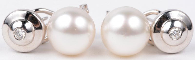 Een paar 18 karaats wit gouden oorbellen bezet met briljanten met een gezamenlijk gewicht van ± 0,14 ct. en twee South-Sea parels van 11,80 mm.