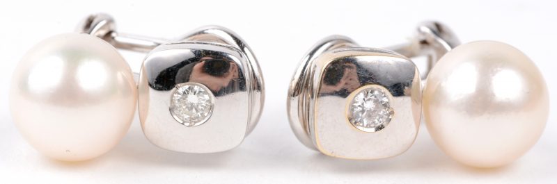 Een paar 18 karaats wit gouden oorbellen bezet met briljanten met een gezamenlijk gewicht van ± 0,14 ct. en twee Akoya parels van 9,20 mm.