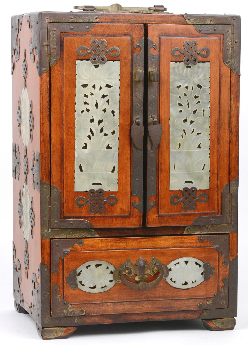Een Chinees juwelenkabinetje van hout, versierd met messingen beslag en met opengewerkte plaquettes van jade.