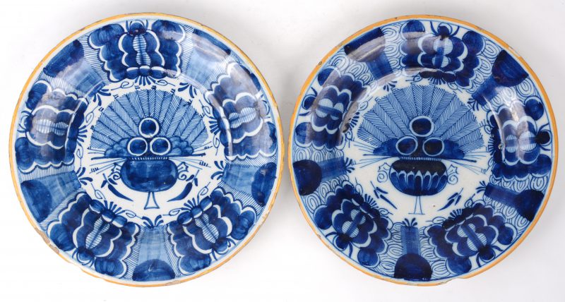 Twee borden van Delfts aardewerk met pauwstaartdecors. Onderaan gemerkt. XVIIIe eeuw.