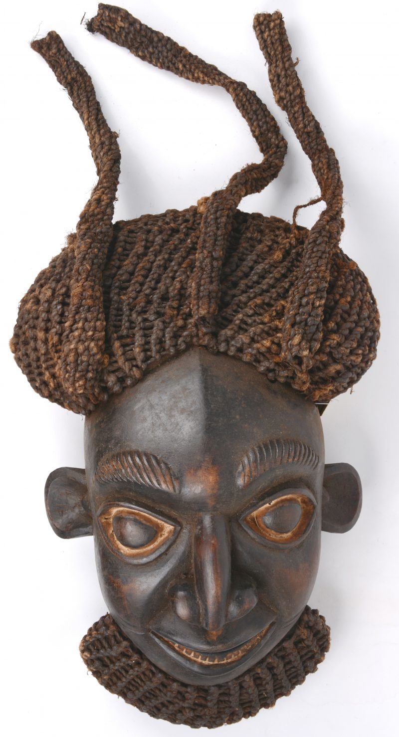 Een Afrikaans houten masker met gevlochten haren.