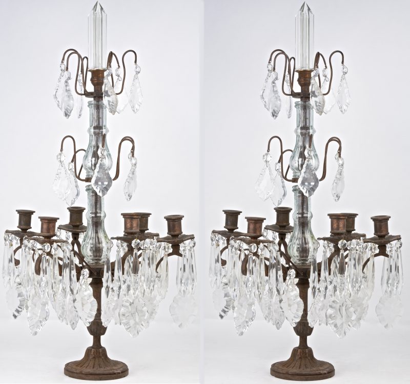 Een paar bronzen girandoles, met zes lichtarmen, versierd met geslepen kristallen pendeloques.