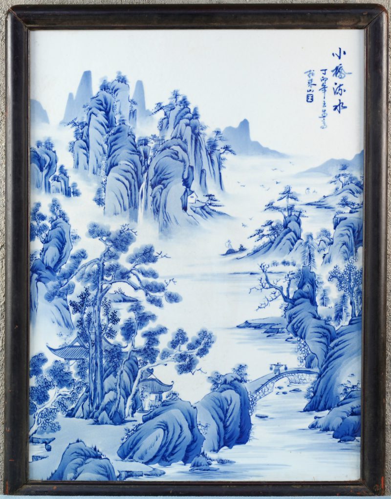 Een Chinees porseleinen wanddecoratie met een blauw op wit landschapsdecor.
