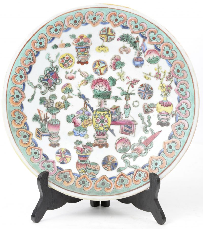 Een bord van Chinees porselein met een meerkleurig decor van kostbaarheden.