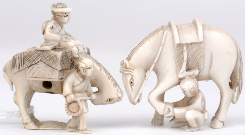 “Reizeigers met paarden”. Twee netsuke’s van fijn gesculpteerd ivoor. Beide gesigneerd. Eerste kwart XXe eeuw.