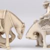 “Reizeigers met paarden”. Twee netsuke’s van fijn gesculpteerd ivoor. Beide gesigneerd. Eerste kwart XXe eeuw.