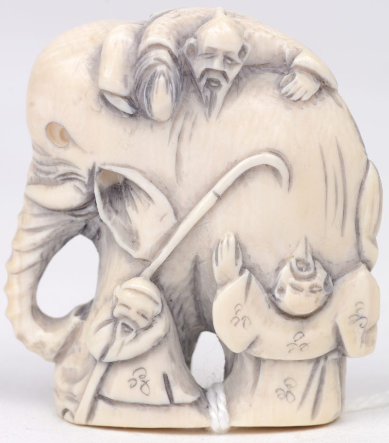 “Drie oude wijzen bij een olifant”. Een netsuke van gesculpteerd ivoor. Gesigneerd. Eerste kwart XXe eeuw.