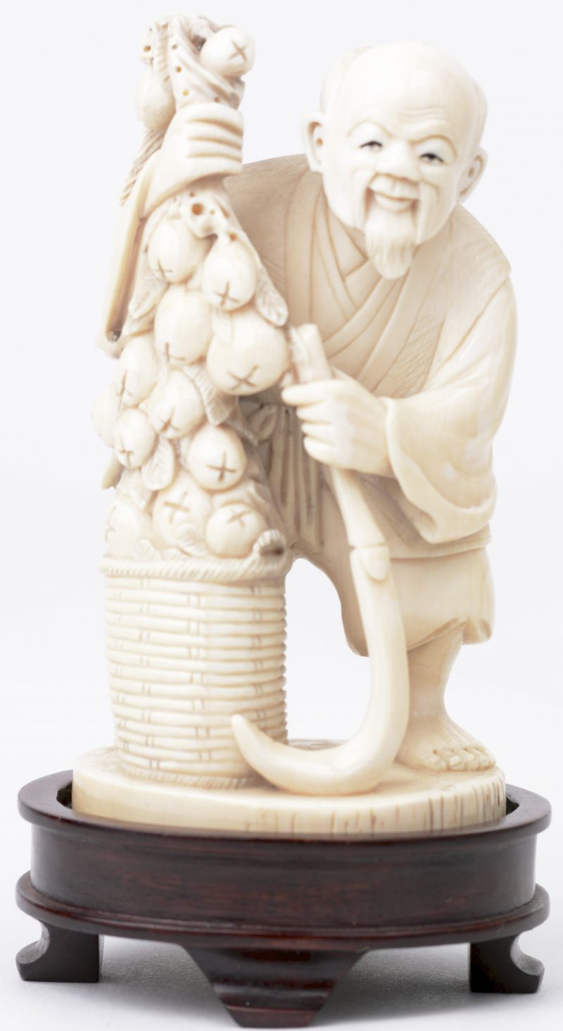 “Man met perziken”. Een okimono van fijn gesculpteerd ivoor. Onderaan gesigneerd. Eerste kwart XXe eeuw. Met houten sokkeltje.
