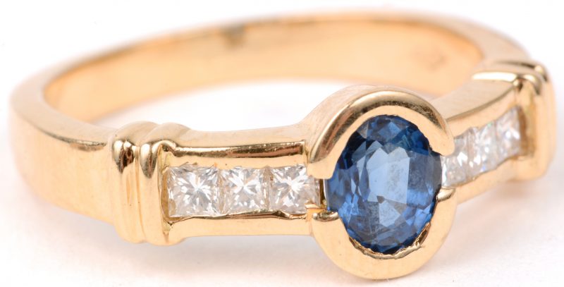 Een 18 karaats geel gouden ring bezet met diamant princessen met een gezamenlijk gewicht van ± 0,30 ct. en een centrale saffier van ± 0,50 ct.
