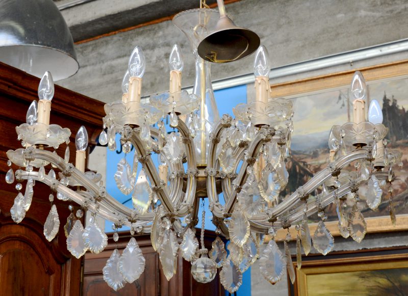 Een Venetiaanse luchter met tien lichtarmen, versierd met kristallen pendeloques.
