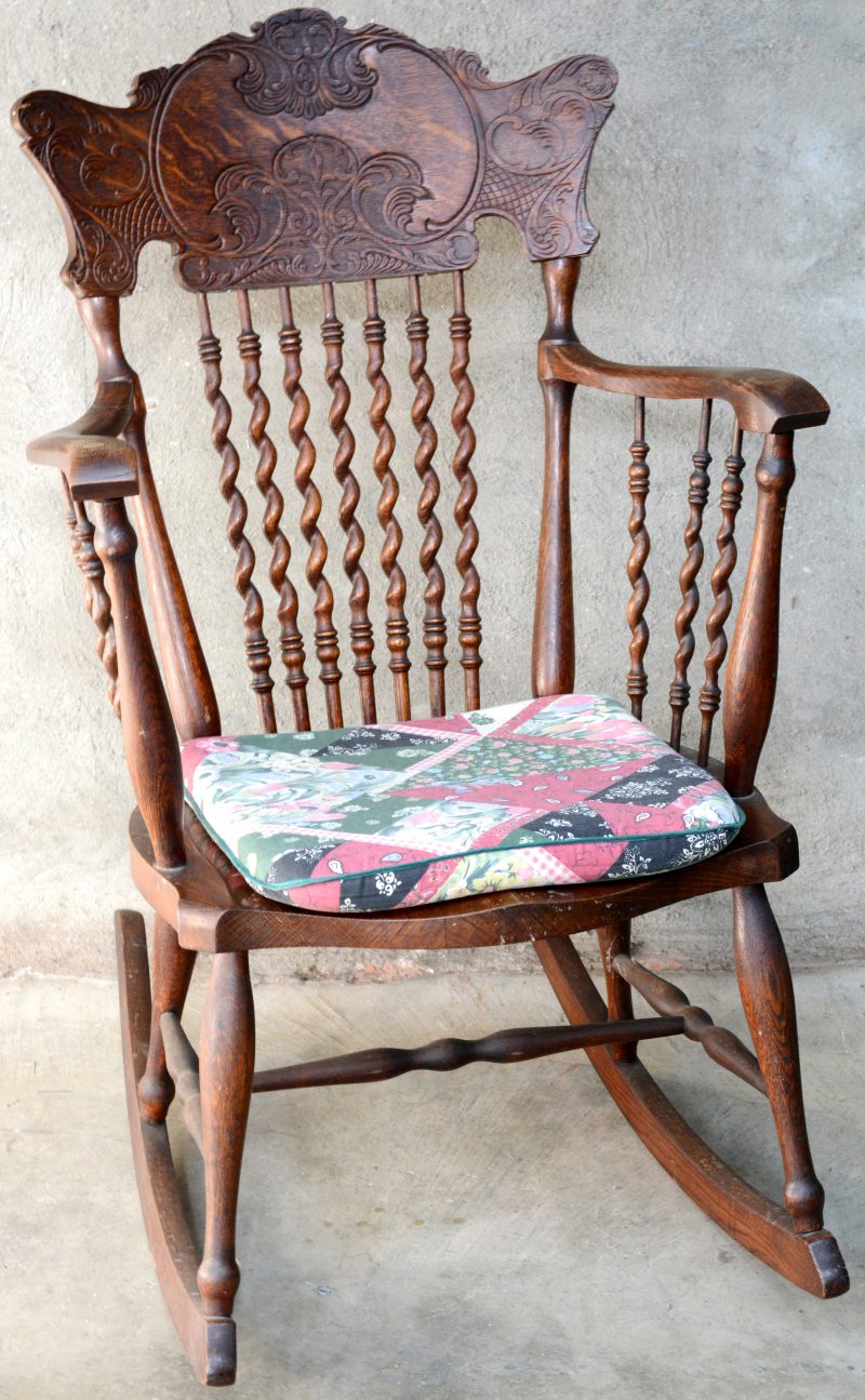 Een eikenhouten schommelstoel met getorste spijlen en gesculpteerde rug