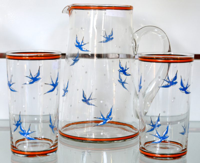 Een schenkkan met twee glazen, versierd met zwaluwen.