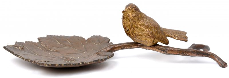 Een bronzen vide-poche in de vorm van een vogeltje op een blad. Met inscriptie 1927  - 1952.