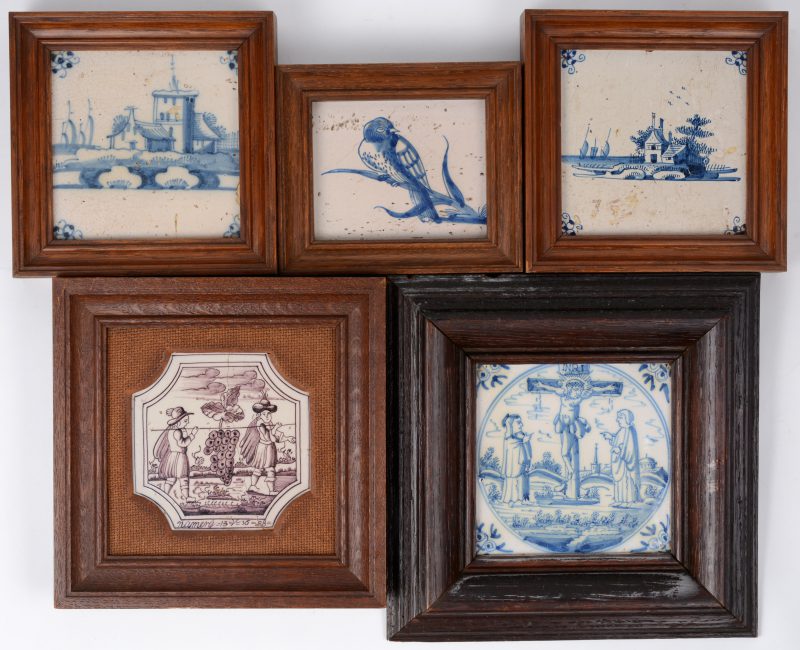 Een lot van vijf ingekaderde Delftse tegels met verschillende decors, waarbij vier in blauw en één in mauve. XIXe eeuw.