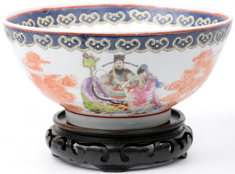Een bowl van meerkleurig Chinees porselein met een decor van personages. Onderaan gemerkt. Met houten sokkel.
