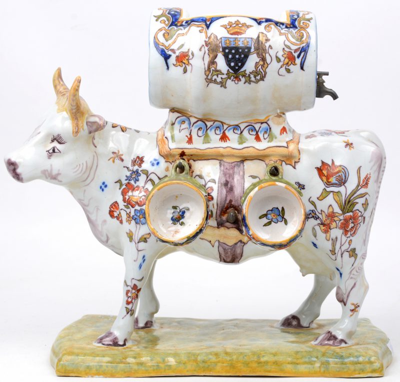 Een koe van meerkleurig Frans aardewerk met bovenaan een tonnetje en met twee kopjes. Onderaan gemerkt. XIXe eeuw.