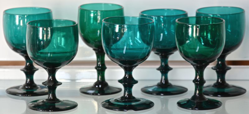 Een set van zeven groene mondgeblazen kristallen glazen.