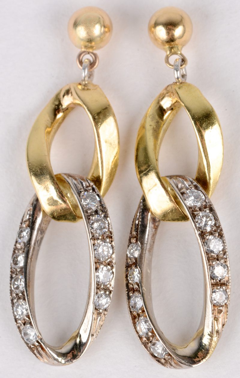 Een paar wit en geel gouden oorbellen bezet met briljanten met een gezamenlijk gewicht van ± 0,70 ct.