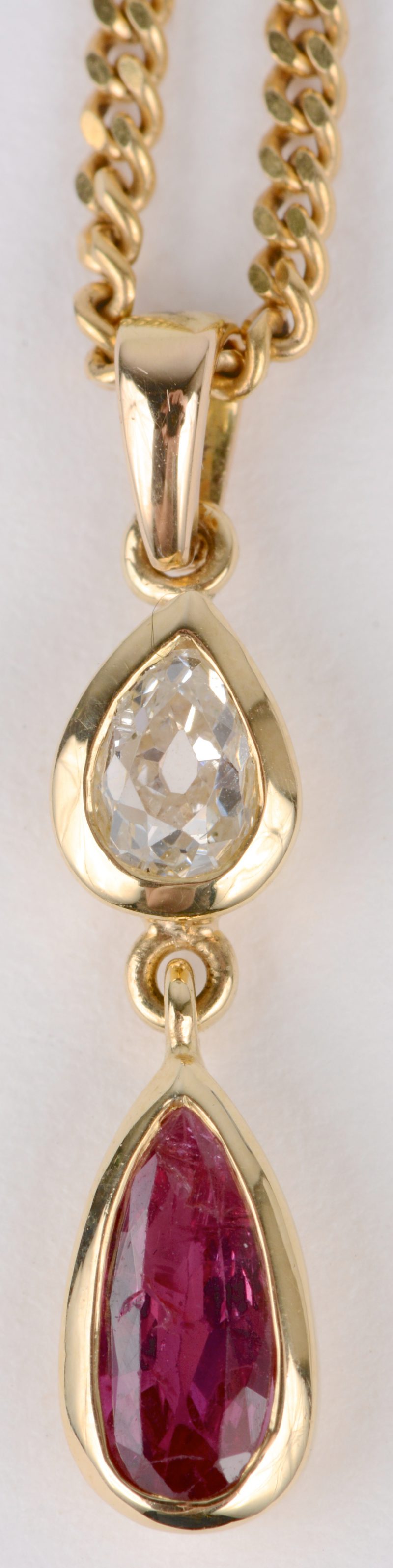 Een 18 karaats geel gouden ketting met hanger bezet met een diamant pear shaped van ± 0,40 ct. en druppelvormige robijn van ± 0,50 ct.