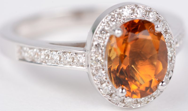 Een 18 karaats wit gouden ring bezet met diamanten met een gezamenlijk gewicht van ± 0,34 ct. en een centrale citrine van ± 1,65 ct.