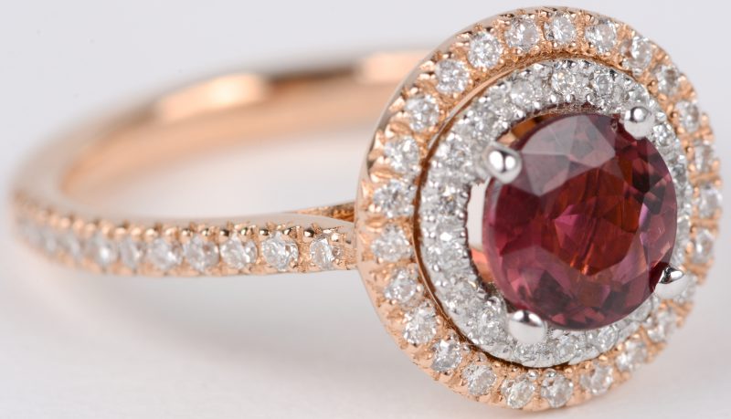 Een 18 karaats roze en wit gouden ring bezet met diamanten met een gezamenlijk gewicht van ± 0,67 ct. en een centrale toermalijn van ± 1 ct.