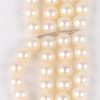 Een vier rijen parelarmband met 18 karaats wit en geel gouden slot bezet met diamanten oude slijp met een gezamenlijk gewicht van ± 1,20 ct. en email.
