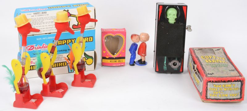 Een lot oud speelgoed, bestaande uit drie ‘Drinking happy birds’, een ‘Coffin bank’ spaarpot en ‘The kissing dolls’. Allen in originele doosjes. Laatste licht beschadigd.