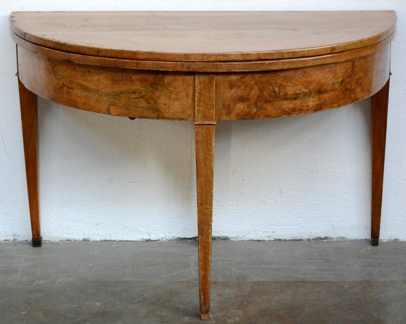 Een halfronde klaptafel van gefineerd hout met tapse poten. Eerste helft XIXe eeuw.