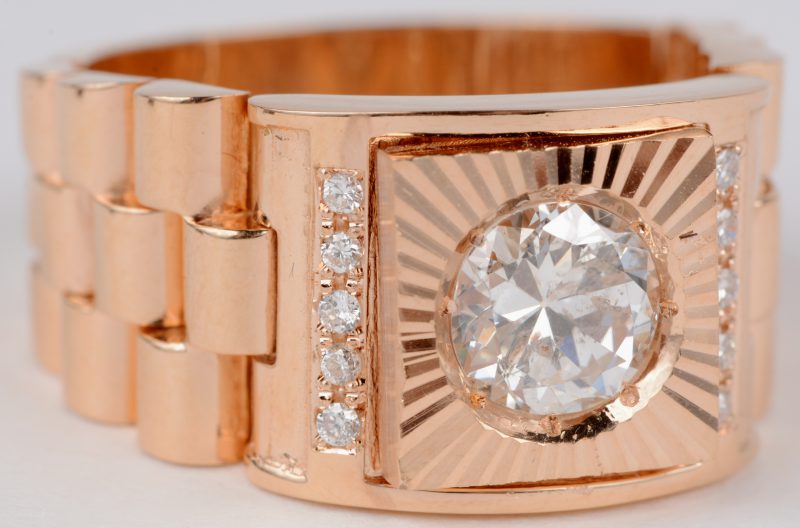 Een 18 karaats roze schakelring bezet met een centrale diamant van ± 1,30 ct. en 10 kleine diamantjes.