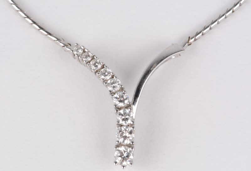 Een 14 karaats wit gouden halssnoer bezet met diamanten met een gezamenlijk gewicht van ± 0,50 ct.
