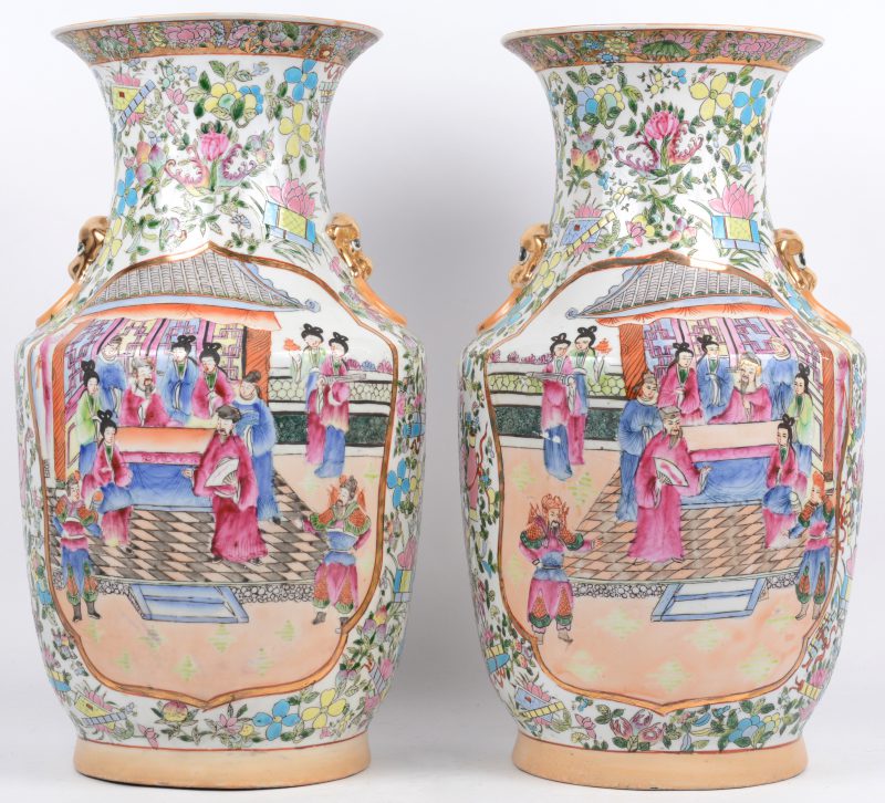 Een paar vazen van meerkleurig Chinees porselein met een decor van een hofhouding in cartouches op een achtergrond van bloemen en kostbaarheden. Onderaan gemerkt. Eén vaas gebarsten.