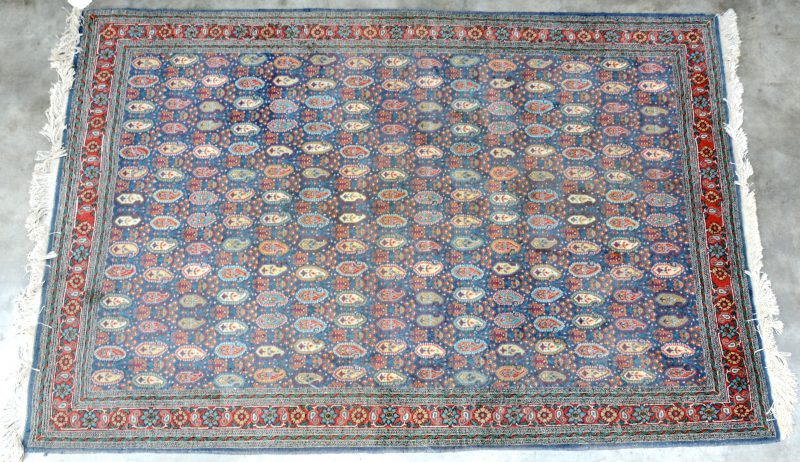 Een handgeknoopt Perzisch wollen karpet met een Boteh-motief.