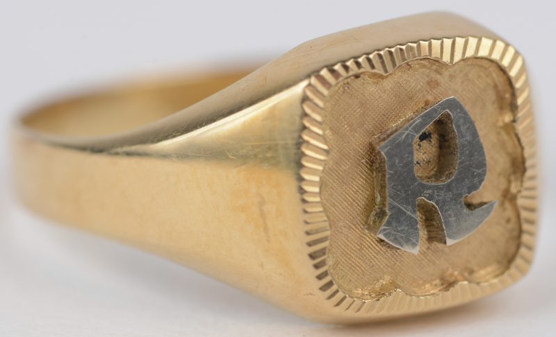 Een 18 karaats wit en geel gouden ring bezet met de letter R.