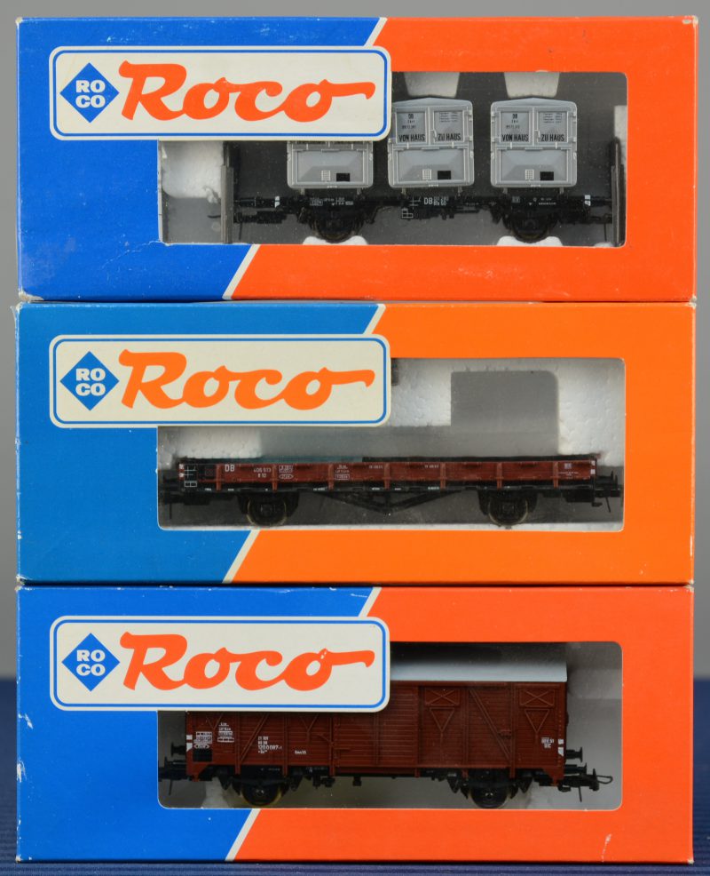 Een lot van drie wagons van de Duitse spoorwegen voor spoortype HO:- Platte wagon (lading ontbreekt).- Wagon met drie containers. - Gesloten houten goederenwagon.