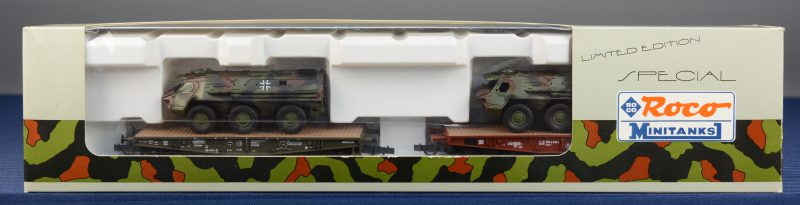Twee platte lastwagons, resp. van de Bundeswehr en van de Deutsche Bahne met twee Fuchs pantservoertuigen als lading. Spoortype HO. In originele doos.