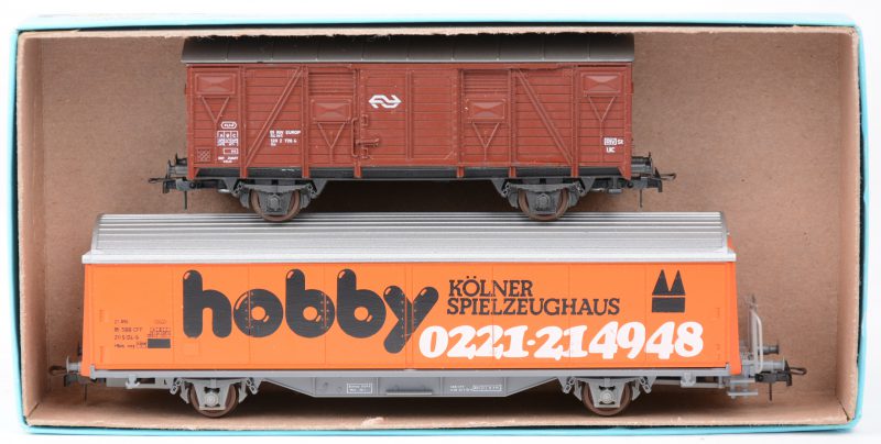 Een gesloten goederenwagon van de Nederlandse spoorwegen en een goederenwagon ‘Hobby’ van de Zwitserse spoorwegen voor spoortype HO.