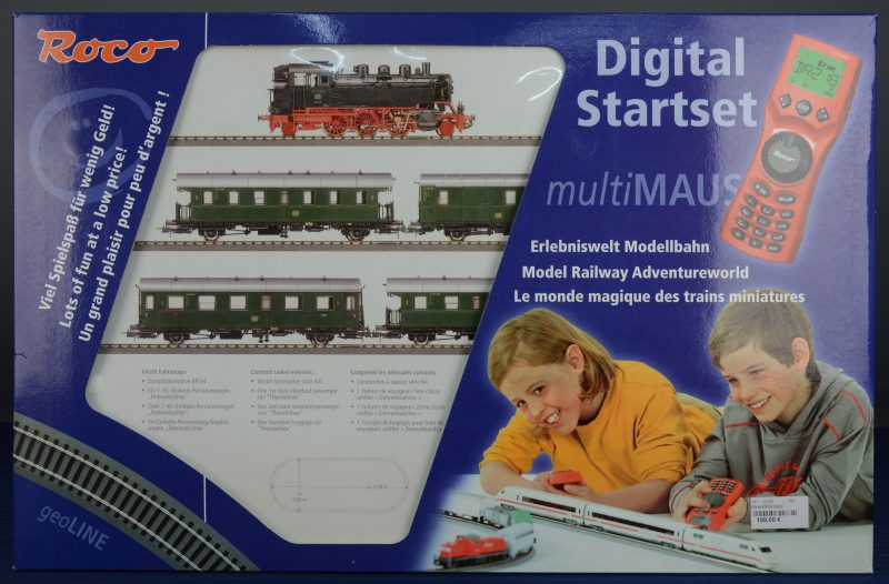 Een digitale startersset met een stoomlocomotief met vier passagierswagons van de Duitse spoorwegen, sporen, een transformator en een ‘multimaus’ draadloos bedieningstoestel. In originele doos. Nieuwstaat.
