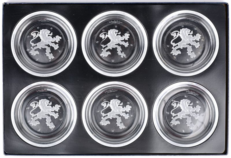 Een reeks van zes onderzetters van kleurloos lristal met geslepen leeuwen in het decor. Allen gemerkt en in origineel etui.