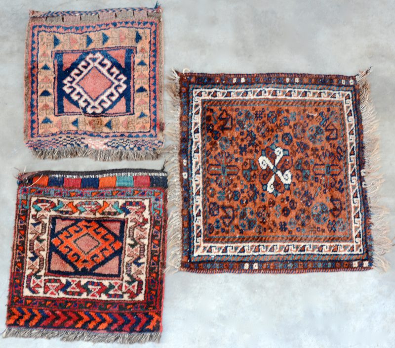 Een lot van drie kleine handgeknoopte Perzische tapijtjes van wol.