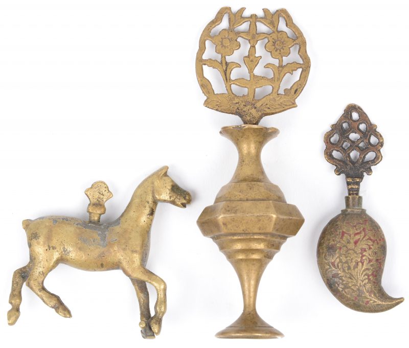 Een lot van drie bronzen snuffbottles, waarbij één in de vorm van een vaasje, het dopje versierd met bloemen, één druppelvormig met opengewerkte dop en met sporen van rode lak en een derde in de vorm van een paard. Indisch werk, omstreeks 1900.