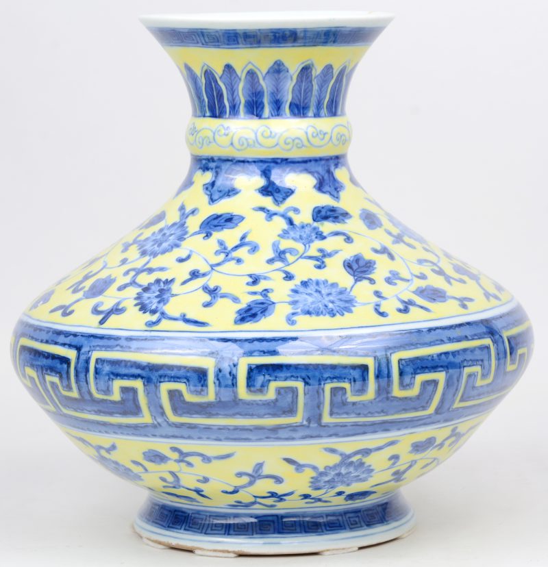 Een brede vaas van Chinees porselein met een blauw en geel decor van bloemen. Onderaan gemerkt.