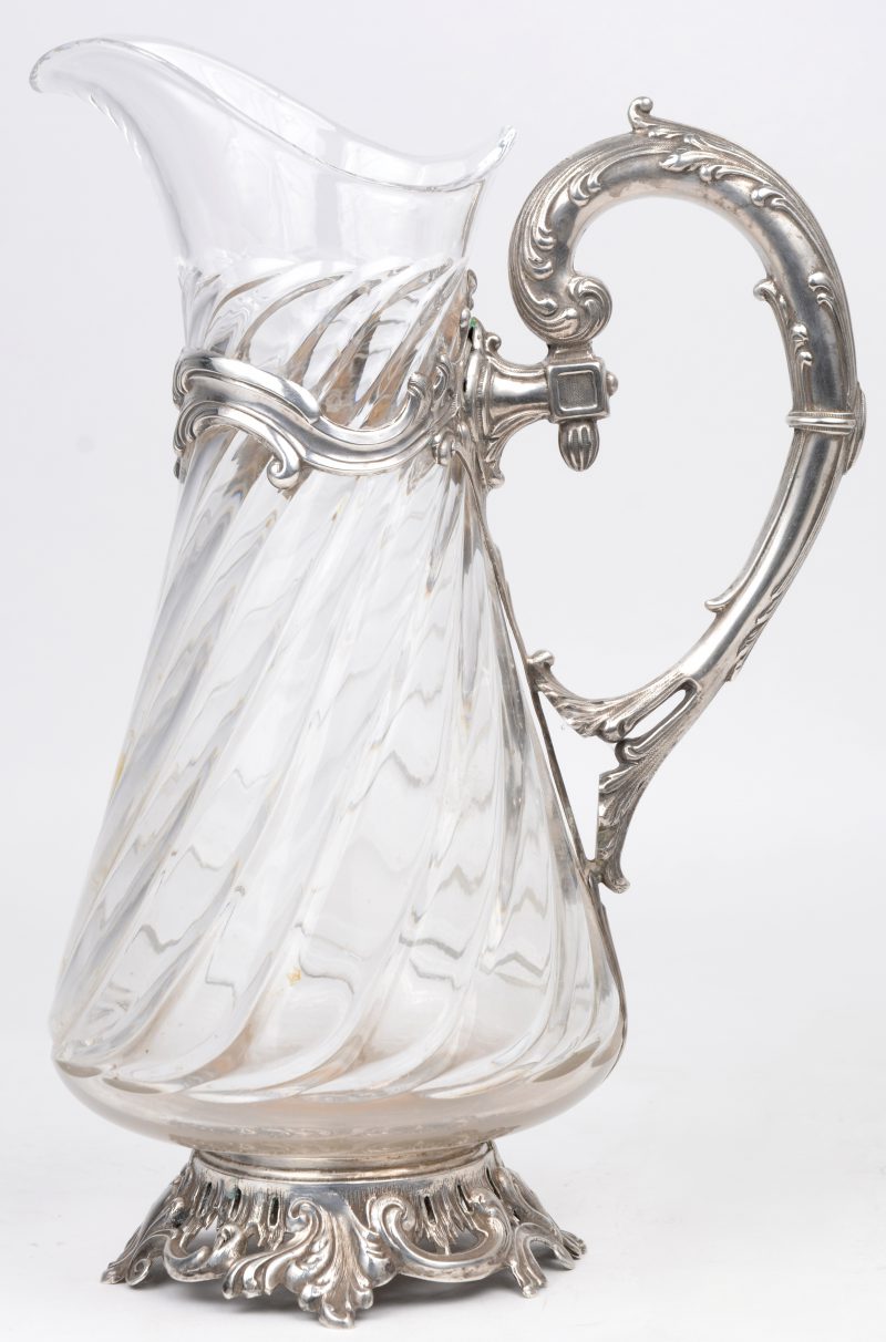 Een geribde schenkkan van kleurloos glas met zilveren handvat, montuur en voet. Makersmerk Roussel. Omstreeks 1900.