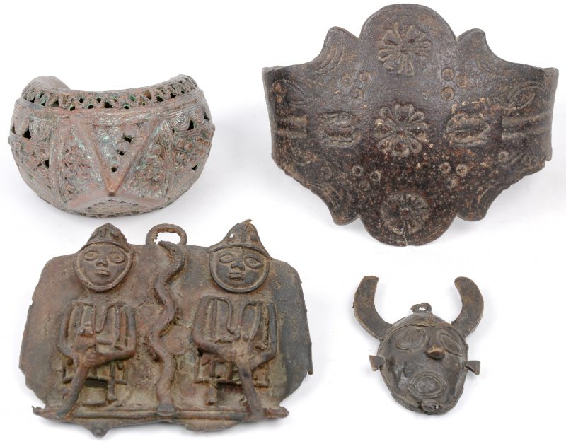 Een lot etnisch brons en smeedijzer, bestaande uit een Indische armband, een Afrikaans maskertje, een Afrikaanse plaquette in hoogreliëf en een montuur met versieringen.