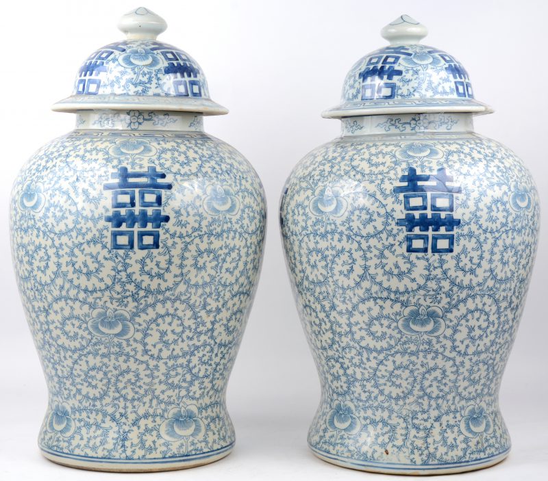 Een paar dekselvazen van Chinees porselein met een blauw op wit decor met langlevenstekens.