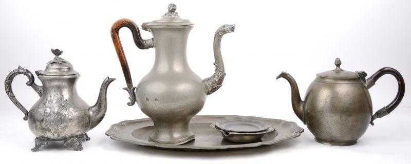 Een lot tin, bestaande uit drie verschillende theekannen, een ovalen serveerschotel, twee onderzetters en een asbak.