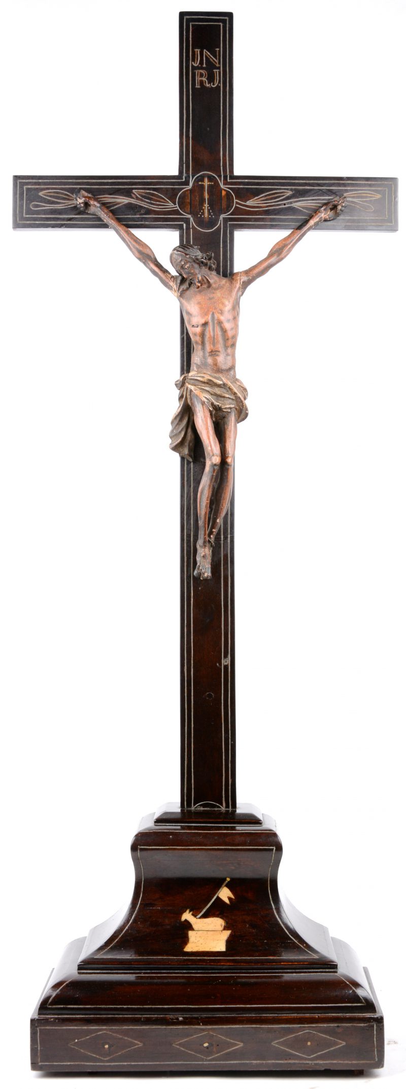 Een ebbenhouten kruisbeeld met een fijn gesneden corpus van lindehout. Het votstuk versierd met een Lam-Gods van ingelegd ivoor.